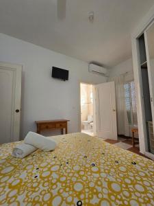 贝纳尔马德纳贝塔尼亚别墅酒店的一间卧室配有一张带黄色毯子的大床