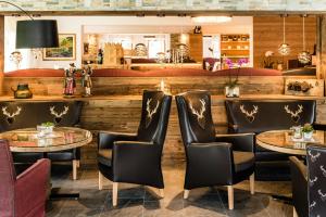 塞尔瓦迪加尔代纳山谷朵夫山魅力酒店的一间带2张桌子和椅子的餐厅和一间酒吧