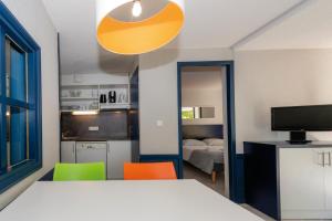 CasteljauResidence Vacances Bleues Lou Castel的一间带床和两把椅子的房间和一间厨房
