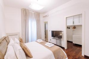 巴里Piccinni Exclusive Suite的卧室配有白色的床和电视。