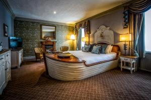 邓凯尔德邓凯尔德之家酒店的一间卧室配有一张大床,内设浴缸
