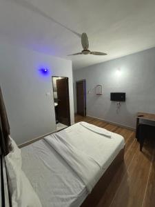 KharakvaslaLotus Guest House的一间卧室配有一张床和吊扇