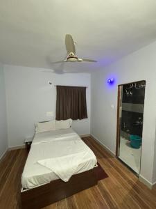 KharakvaslaLotus Guest House的一间卧室配有一张床和吊扇
