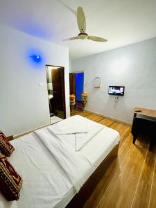 KharakvaslaLotus Guest House的一间卧室配有一张大床和吊扇