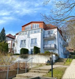 萨斯尼茨Ferienwohnung in Sassnitz RÜGEN Nähe Weltnaturerbe Kreideküste的白色房子,有红色屋顶