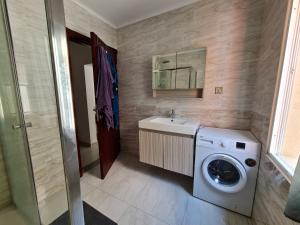 罗安达Lovely 1-Bed Apartment in Luanda的一间带洗衣机和水槽的浴室