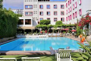 盖尼特拉Hotel Mamora Kénitra的一座带椅子的大型游泳池和一座建筑