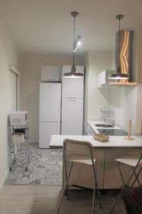 托莱多Apartamento Nuncio Viejo by Toledo AP的厨房配有白色家电和桌椅