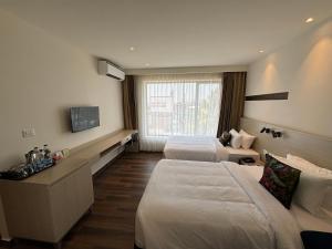 科钦PRESIDENCY AIRPORT HOTEL的酒店客房设有两张床和电视。