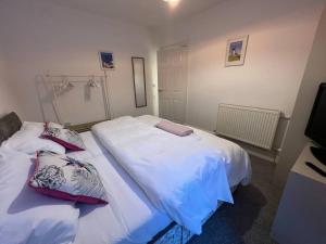 滨海圣安娜New Flat in Lytham St Annes - Sleeps 4的卧室内的两张床,配有白色床单和枕头