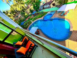 GoaShivam Resort With Swimming Pool ,Managed By The Four Season - 1 km from Calangute Beach的享有带两把椅子的游泳池的顶部景致