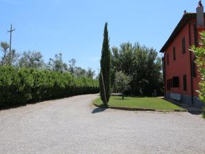 蒙塔尔托迪卡斯特罗Chic Farmhouse in Montalto di Castro with Terrace的一条有树的红楼旁的道路