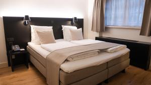 利赫塔特Corsendonk Hooge Heyde的卧室配有一张带白色床单和枕头的大床。