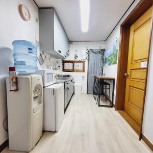 首尔Cozy Private Home Newly Renovated的一间厨房,配有白色家电和木门