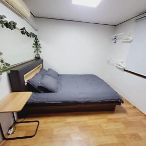 首尔Cozy Private Home Newly Renovated的一间小卧室,配有一张床和一张桌子