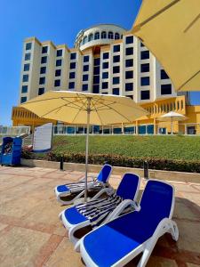 豪尔费坎豪尔法坎海洋度假水疗酒店的一组椅子和一把伞,一座建筑