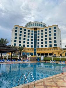 豪尔费坎豪尔法坎海洋度假水疗酒店的大型酒店前方设有大型游泳池