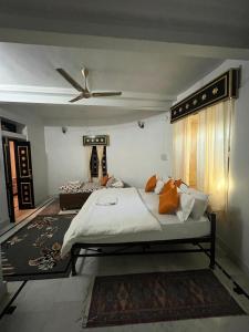 斋沙默尔Hostel Desert Home Stay的一间卧室配有一张带橙色枕头的大床