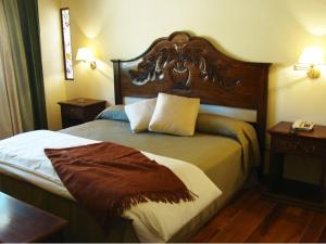 普尔马马尔卡Hotel Marqués De Tojo的酒店客房,配有一张带木制床头板的床
