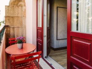 波尔图ibis Porto Centro Mercado Bolhao的红色的门和阳台的桌椅