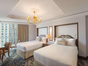 麦加莱佛士酒店的酒店客房设有两张床和吊灯。