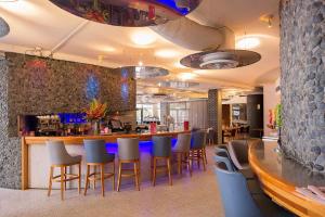 珀斯Metro Hotel Perth City的餐厅内的酒吧配有椅子和柜台
