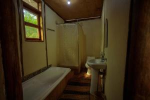 Kasendalake mwamba lodge的带浴缸、盥洗盆和卫生间的浴室