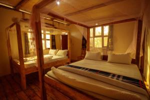 Kasendalake mwamba lodge的一间卧室设有两张床和两个窗户。