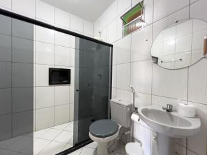 凯鲁Pousada Praia da Cueira的一间带卫生间、水槽和镜子的浴室