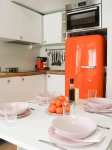 斯德哥尔摩La Petite bohéme with free parking的厨房配有白色橱柜和橙色冰箱
