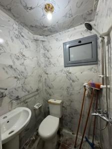 曼苏拉شقه صغيره فندقيه في موقع مميز جديده وفرش وموبيليا جديده的一间带卫生间和水槽的浴室以及一台电视。