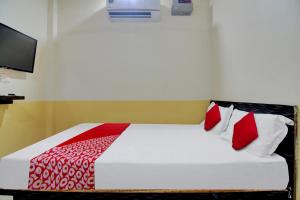 那格浦尔Super OYO Flagship Hotel Vinit Lodging的一间卧室配有红色和白色枕头的床