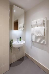 伦敦Studio at Florence Dock的浴室配有盥洗盆、镜子和毛巾