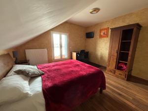 孔夫朗-圣奥诺里讷巴塞罗奥酒店的一间卧室配有一张床铺,床上铺有红色毯子