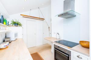 伦敦Stylish 1BR apt, 7min Archway Tube & Holloway Rd的厨房配有白色橱柜和台面