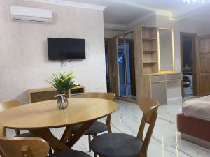 第比利斯Tbili Metekhi Boutique Hotel的客厅配有桌椅和电视。