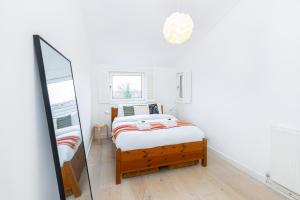 伦敦Stylish 1BR apt, 7min Archway Tube & Holloway Rd的白色卧室配有床和镜子