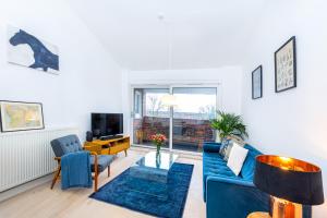 伦敦Stylish 1BR apt, 7min Archway Tube & Holloway Rd的客厅配有蓝色的沙发和电视