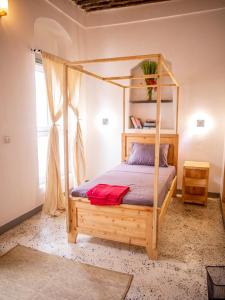 巴加莫约Firefly Boutique Lodge的一间卧室配有一张带木制床架的床