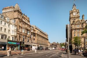 爱丁堡英国皇家王子街酒店的一条城市街道,有钟楼和建筑
