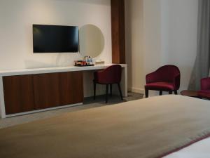 埃尔比勒Ramada Hotel & Suites by Wyndham Erbil 32 Park的酒店客房设有电视和两把椅子