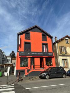 孔夫朗-圣奥诺里讷巴塞罗奥酒店的一座橙色的建筑,前面有停车位