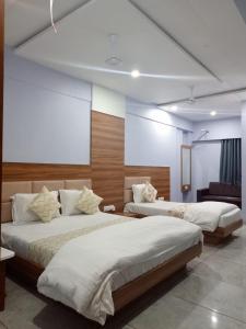 NarodaHotel Red Blue,Ahmedabad的白色墙壁客房的两张床