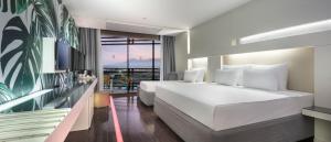 拉瑞Nirvana Cosmopolitan的酒店客房设有两张床和一个阳台。
