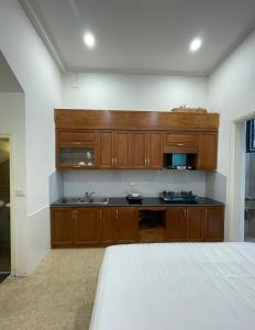 河内Dodo home XD的一个带木制橱柜的厨房和一张位于客房内的床