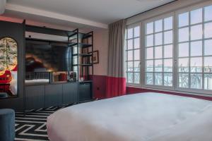 图尔LABE Hôtel Tours Centre Gare的一间卧室设有一张大床和大窗户