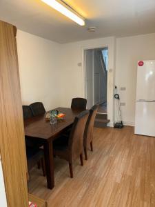 卡迪夫Cardiff Grangetown Stylish 3Bed House.的一间带桌椅和冰箱的用餐室