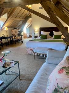 TrangéHôtel du Domaine de La Groirie - Le Mans的阁楼上设有一间卧室,配有两张床和一张沙发