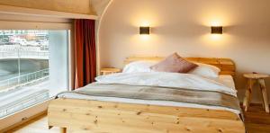巴塞尔Silo Design & Boutique Hostel Basel的一间卧室设有一张木床和大窗户