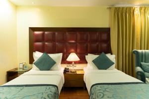新德里The Grand Orion - Kailash Colony的酒店客房配有两张床和一张书桌